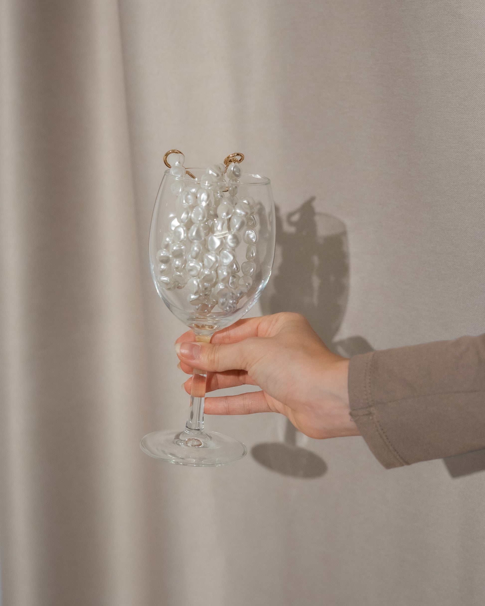 Close-up of a chic pearl phone wristlet, as seen on Netflix's Emily in Paris. This elegant accessory combines timeless style with modern functionality, perfect for adding a touch of Parisian flair to any outfit. Phone Accessory for any girl and any phone.