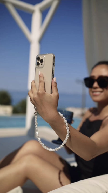 Close-up of a chic pearl phone wristlet, as seen on Netflix's Emily in Paris. This elegant accessory combines timeless style with modern functionality, perfect for adding a touch of Parisian flair to any outfit. Phone Accessory for any girl and any phone.