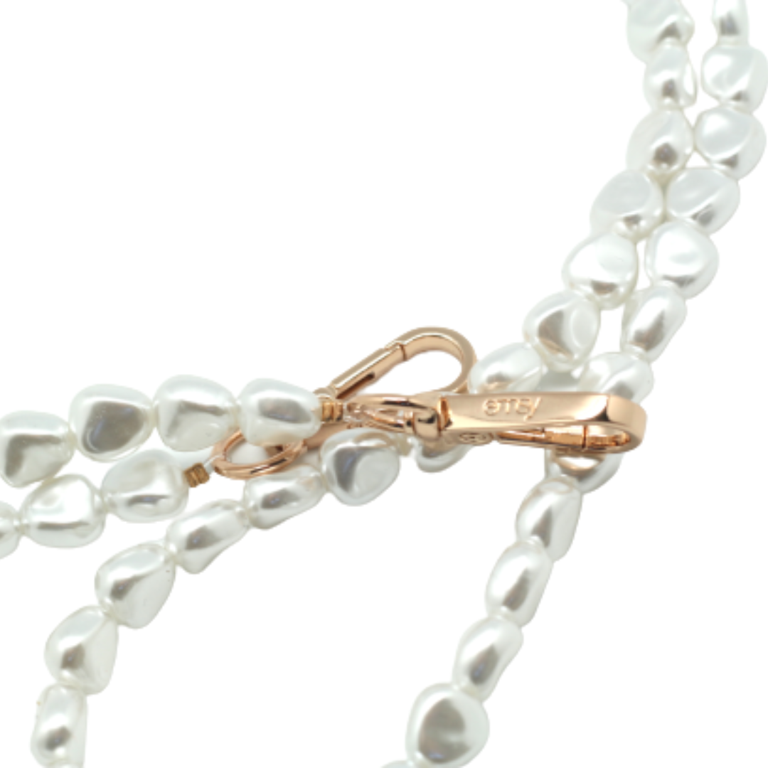 Close-up of a chic pearl phone wristlet, as seen on Netflix's Emily in Paris. This elegant accessory combines timeless style with modern functionality, perfect for adding a touch of Parisian flair to any outfit. Phone Accessory for any girl and any phone.