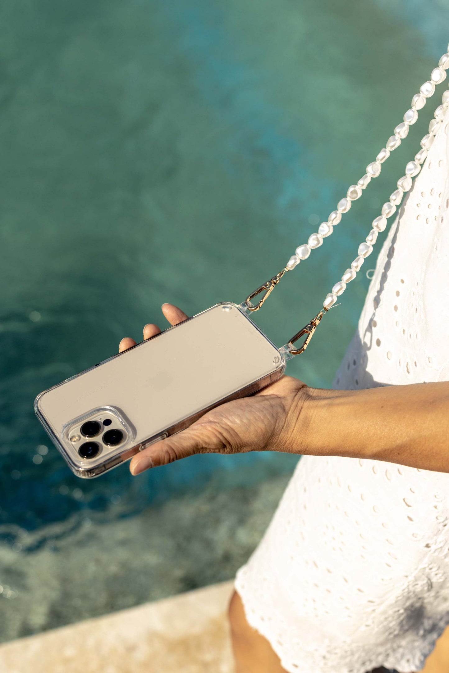 Close-up of a chic pearl phone wristlet, as seen on Netflix's Emily in Paris. This elegant accessory combines timeless style with modern functionality, perfect for adding a touch of Parisian flair to any outfit. Phone Accessory for any girl and any phone.
