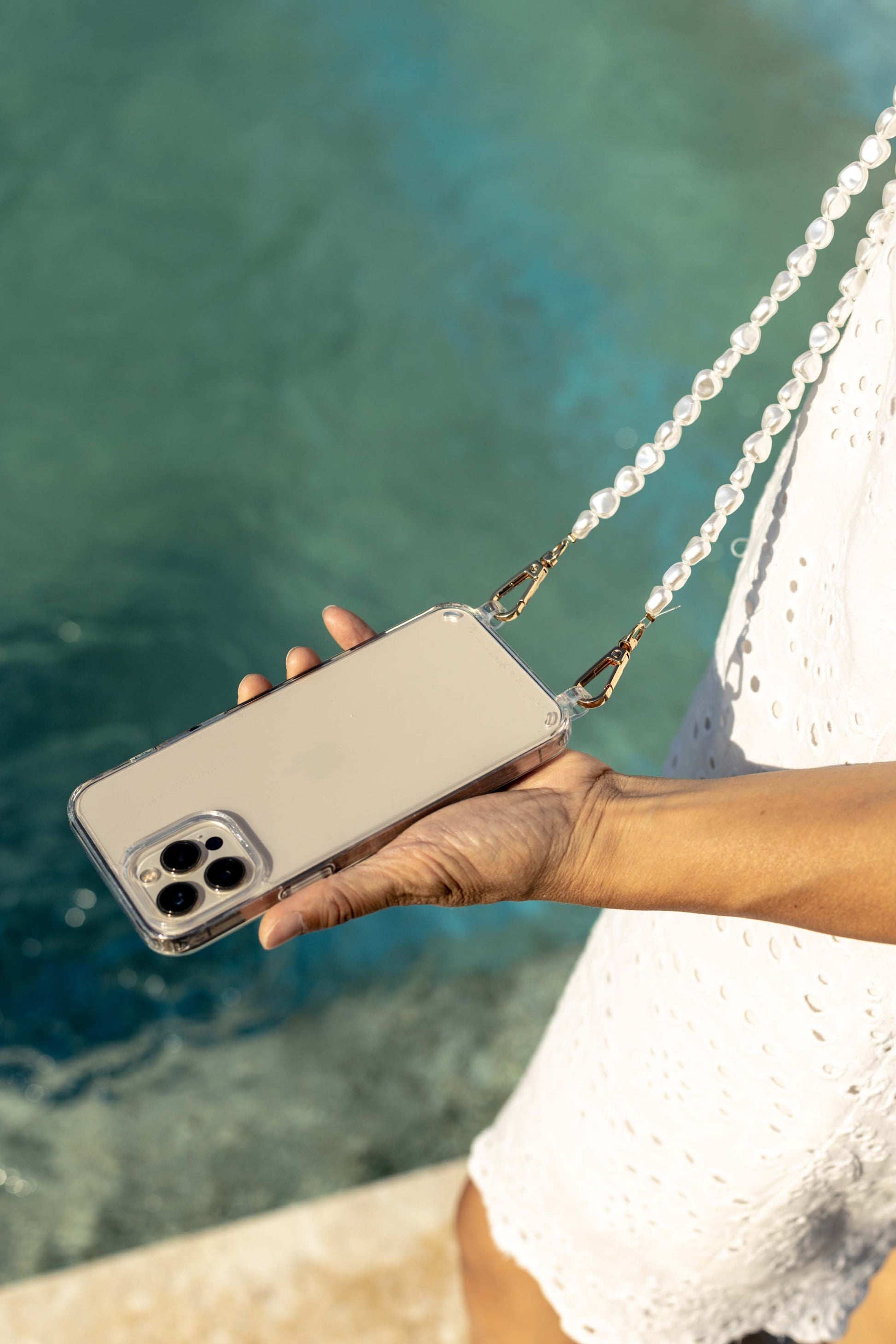 Close-up of a chic pearl phone wristlet, as seen on Netflix's Emily in Paris. This elegant accessory combines timeless style with modern functionality, perfect for adding a touch of Parisian flair to any outfit. Phone Accessory for any girl and any phone.